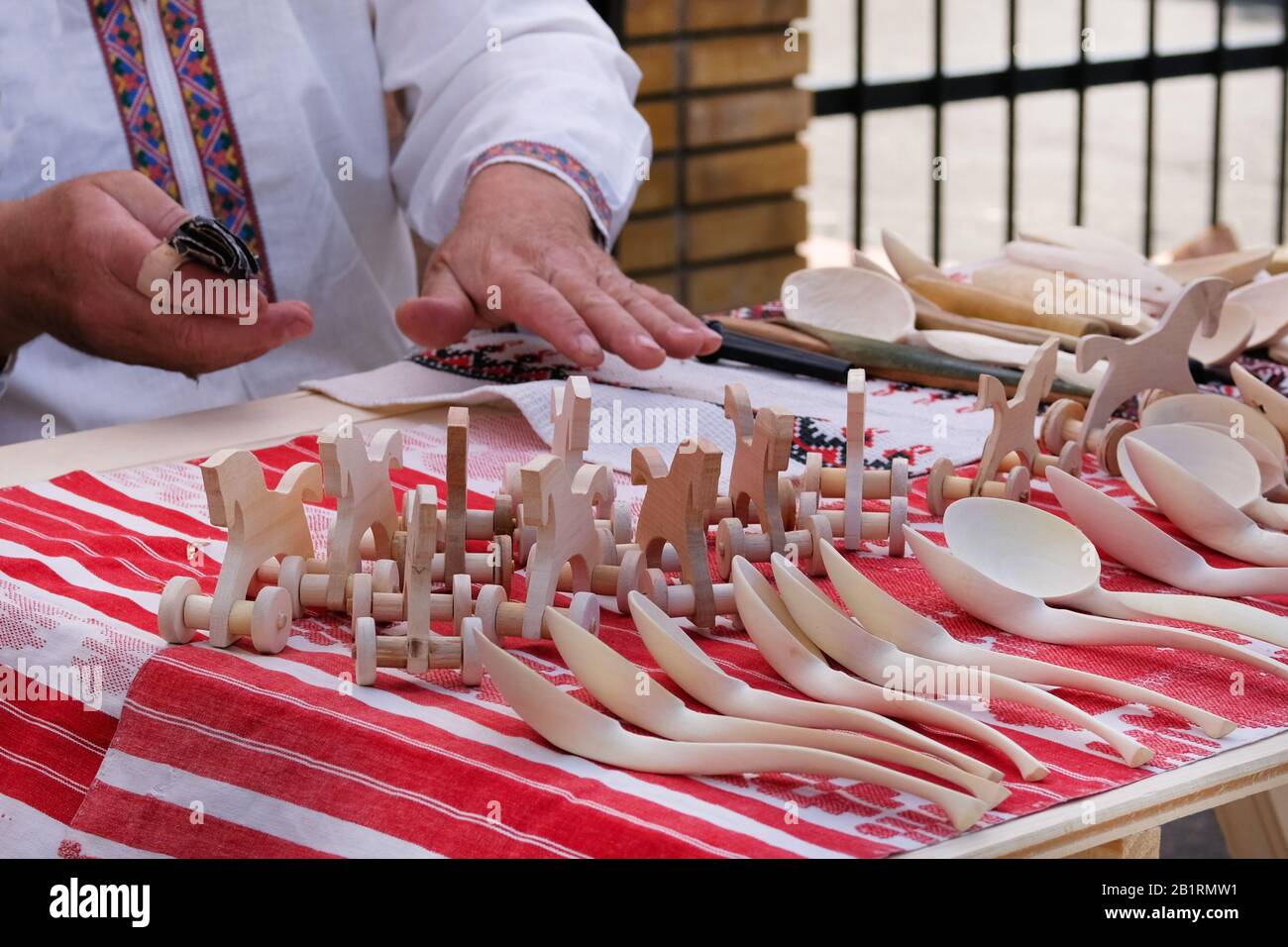 Handwerker stellten zum Verkauf handgefertigtes Holzspielzeug und Löffel auf. Konzept des nationalen Handwerks. Stockfoto