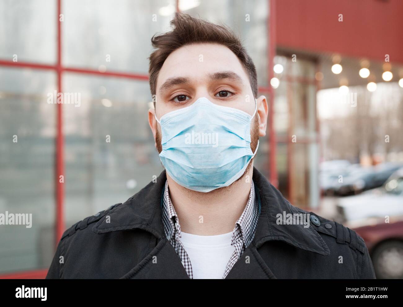 Europäisches Coronavirus. Porträt des kaukasischen Mannes, der eine hygienische Gesichtsmaske trägt, Atemschutzmaske im Freien. Viren-, Coronavirus- und Luftschutz Stockfoto