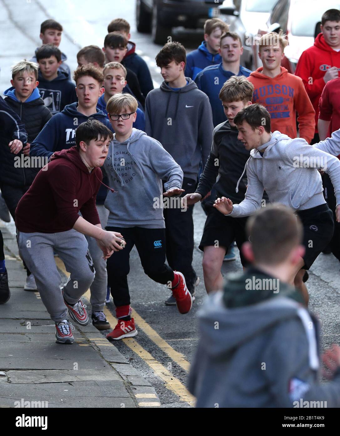 Boys tussle für den Lederball während der jährlichen Jedburgh BA' Game Event auf Jedburgh's High Street in the Scottish Borders.Bilddatum: Donnerstag, 27. Februar 2020. Die jährliche Veranstaltung begann in den 1700er Jahren und das erste Spiel überhaupt wurde angeblich mit einem Engländer Kopf gespielt. Es beinhaltet zwei Teams, die Uppies (Bewohner aus dem oberen Teil von Jedburgh) und die Doonies (Bewohner aus dem unteren Teil von Jedburgh) bekommen den Ball entweder auf der Oberseite oder Unterseite der Stadt. Der Ball, der aus Leder, gefüllt mit Stroh und verziert mit Bändern, die Haare, wird in die geworfen Stockfoto