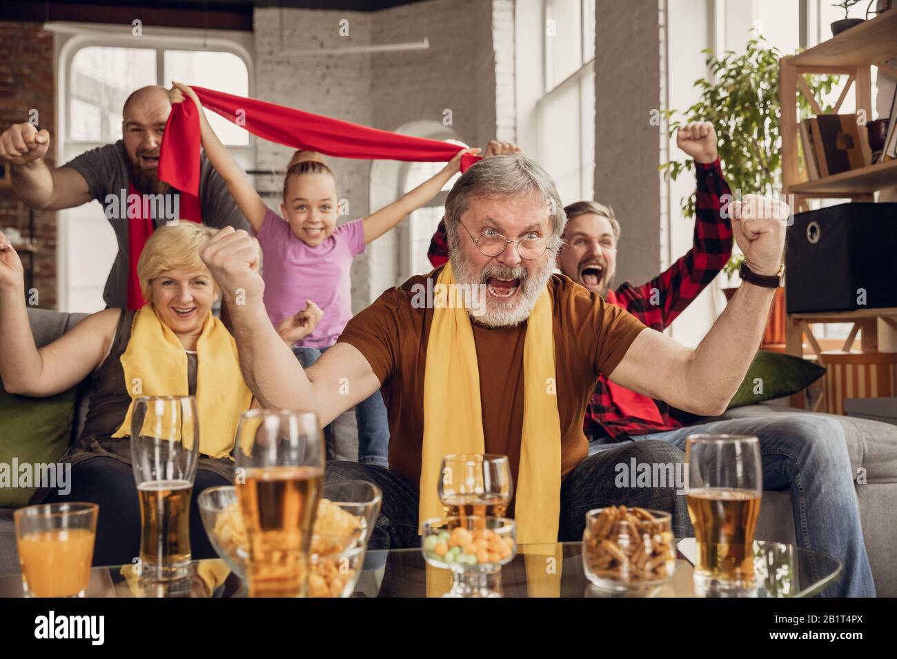 Aufgeregt, glücklich, die große Familie beim Fußball, Fußball, Basketball, Hockey, Tennis, Rugbyspiel auf der Couch zuhause beobachtet. Fans emotional jubeln für Lieblings-Nationalmannschaft. Sport, TV, Meisterschaft. Stockfoto