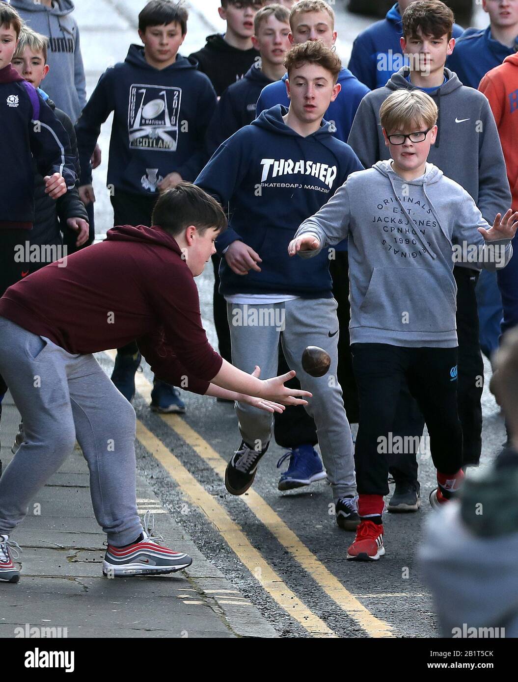 Boys tussle für den Lederball während der jährlichen Jedburgh BA' Game Event auf Jedburgh's High Street in the Scottish Borders.Bilddatum: Donnerstag, 27. Februar 2020. Die jährliche Veranstaltung begann in den 1700er Jahren und das erste Spiel überhaupt wurde angeblich mit einem Engländer Kopf gespielt. Es beinhaltet zwei Teams, die Uppies (Bewohner aus dem oberen Teil von Jedburgh) und die Doonies (Bewohner aus dem unteren Teil von Jedburgh) bekommen den Ball entweder auf der Oberseite oder Unterseite der Stadt. Der Ball, der aus Leder, gefüllt mit Stroh und verziert mit Bändern, die Haare, wird in die geworfen Stockfoto