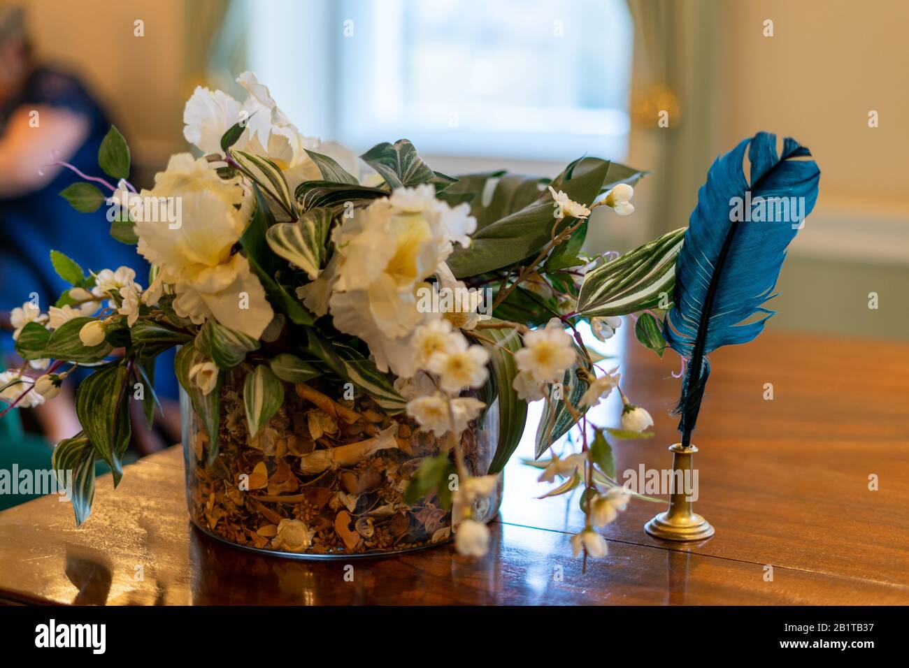 Ein blauer Schreibquill auf einem Tisch neben Blumen bei einer Hochzeitsfeier Stockfoto