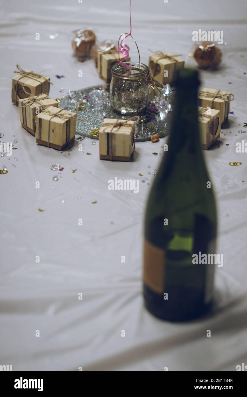 Selektive Fokussierung auf ein Herzstück auf einem Hochzeitstisch mit einer Flasche Champagner im Vordergrund Stockfoto