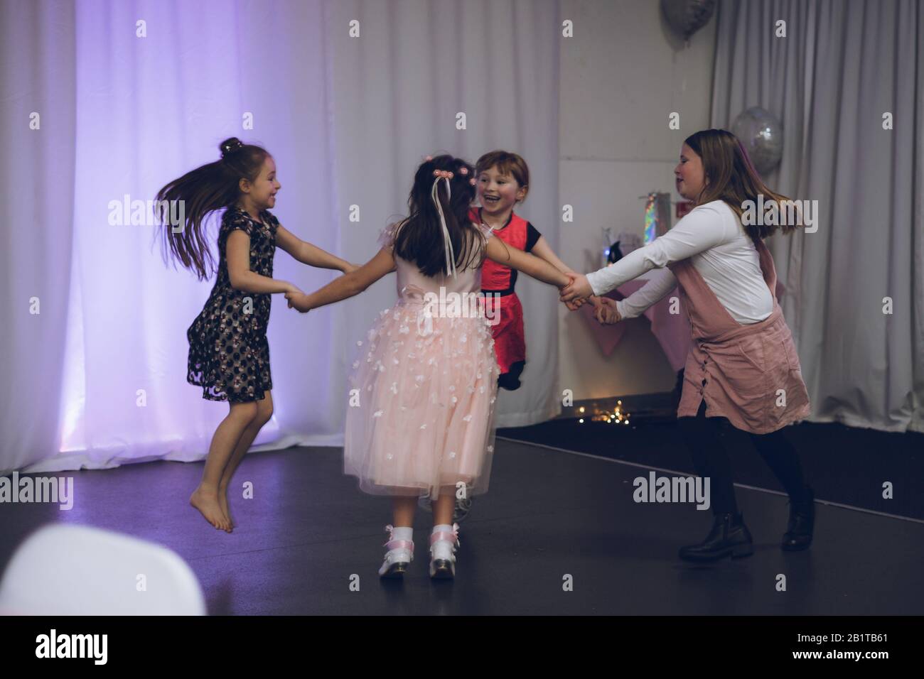 Junge Mädchen tanzen zusammen und halten die Hände auf einer Party Stockfoto