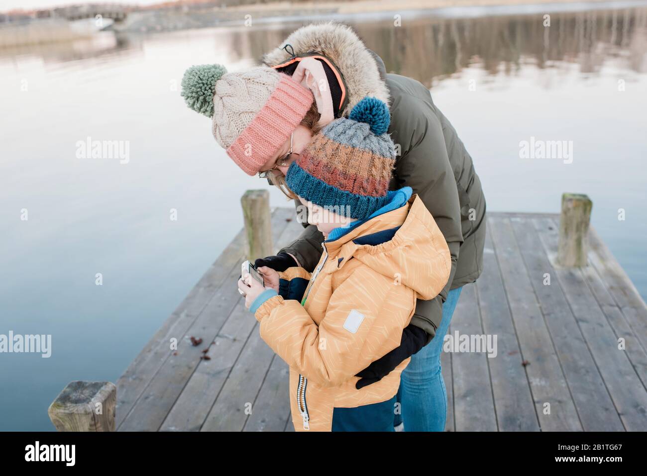 Mama schaut sich Bilder an einer Kamera mit ihrem Sohn draußen im Winter Stockfoto