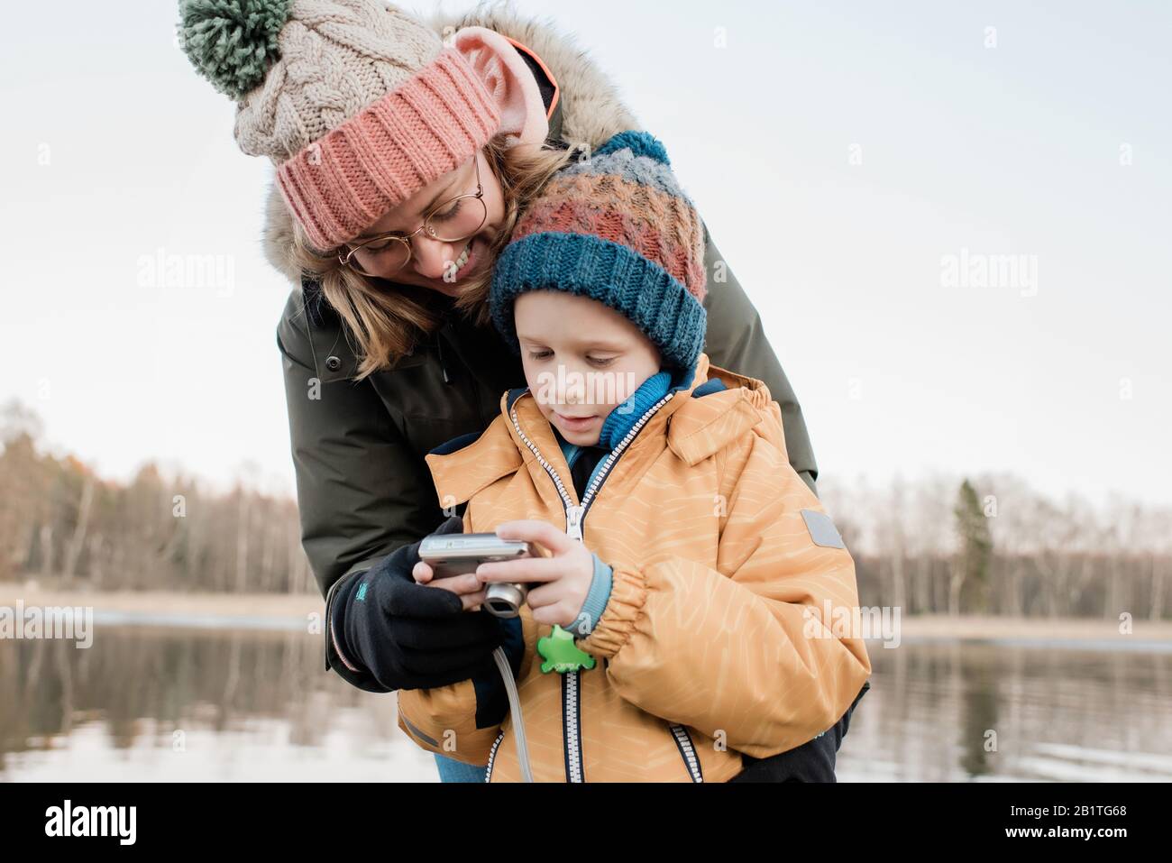 Mama schaut auf eine Kamera mit ihrem Sohn draußen fotografieren Stockfoto
