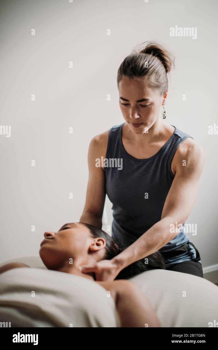 Weibliche Massagetherapeutin behandelt ihre afroamerikanische Patientin