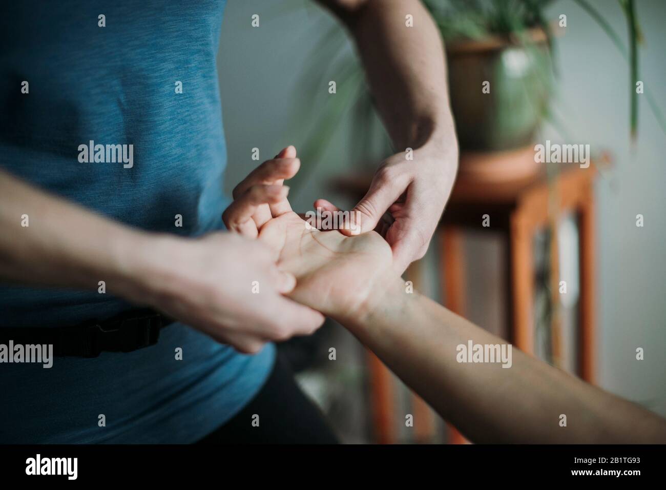 Nahaufnahme eines Massagetherapeuten, der die Hand eines Patienten massiert. Stockfoto