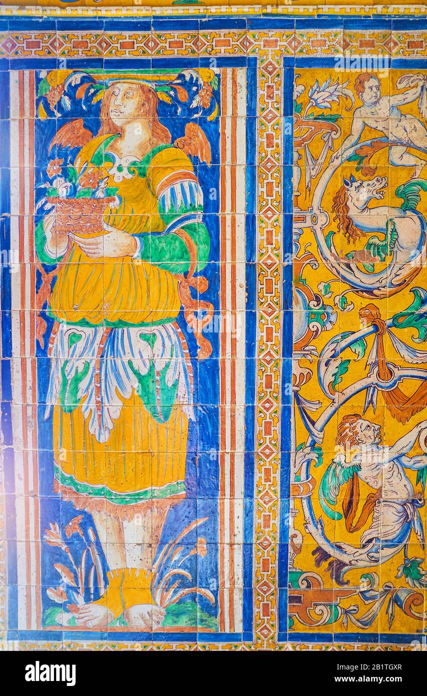 Die schönen Dekorationen des Alcazar-Palastes mit großer historischer Fliesenwand mit erstaunlichen Bildern der Person, die den Blumentopf, Sevilla, Spai, hält Stockfoto