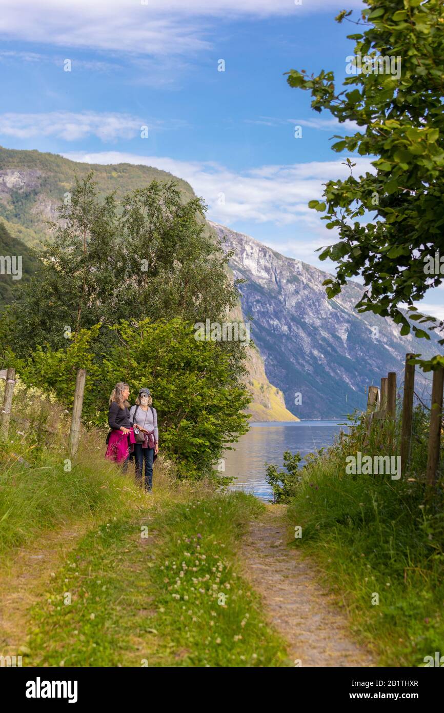 Undredal, NORWEGEN - Zwei Frauen Wanderer auf Wiese, am Aurlandsfjorden, einem Fjord im Vestland County. Stockfoto