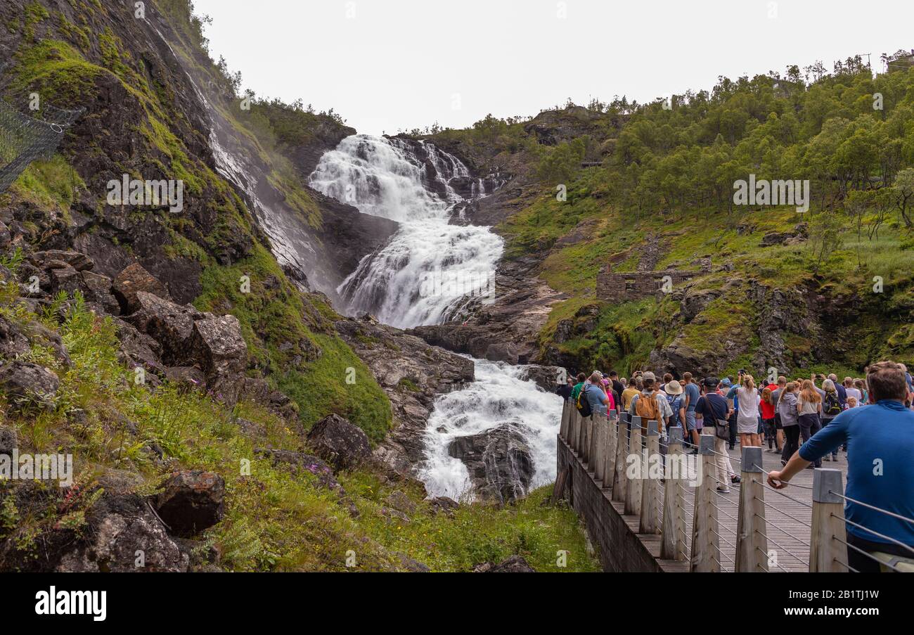 Flam, NORWEGEN - Touristen am Wasserfall von Rjoandesossen in der Nähe der Flam Line Railroad. Stockfoto