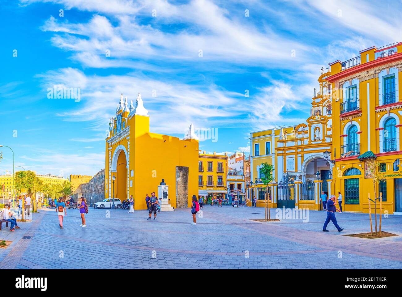 Sevilla, SPANIEN - 1. OKTOBER 2019: Ensemble des Esperanza Macarena Platzes mit historischem Macarena Tor und Basilika, in gelb-weißen Farben dekoriert mit Witz Stockfoto Sevilla, SPANIEN - 1. OKTOBER 2019: Ensemble des Esperanza Macarena Platzes mit historischem Macarena Tor und Basilika, in gelb-weißen Farben dekoriert mit Witz Stockfoto