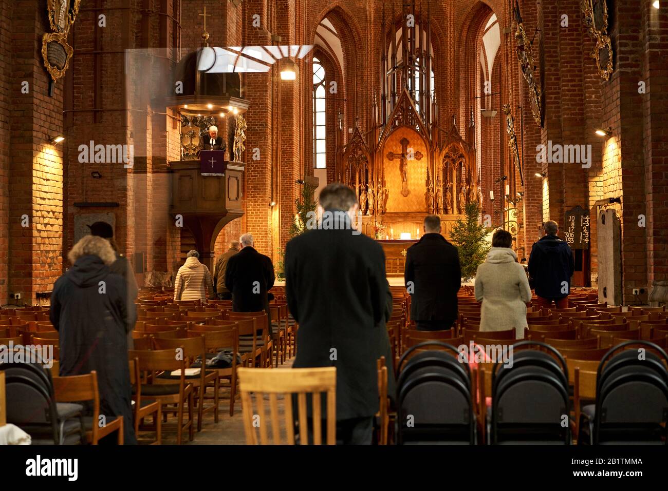 Riga, Lettland - 8. Dezember 2019. Die Menschen stehen während des morgendlichen Sonntagsgebets im Inneren der Kirche Stockfoto