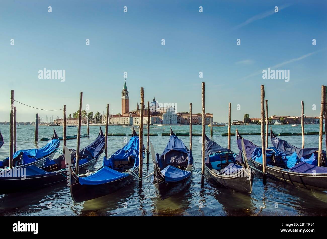 Die Gondelbahn-Pier-Reihe lag am Canal Grande mit der Kirche San Giorgio Maggiore im Hintergrund, Venedig, Italien Stockfoto