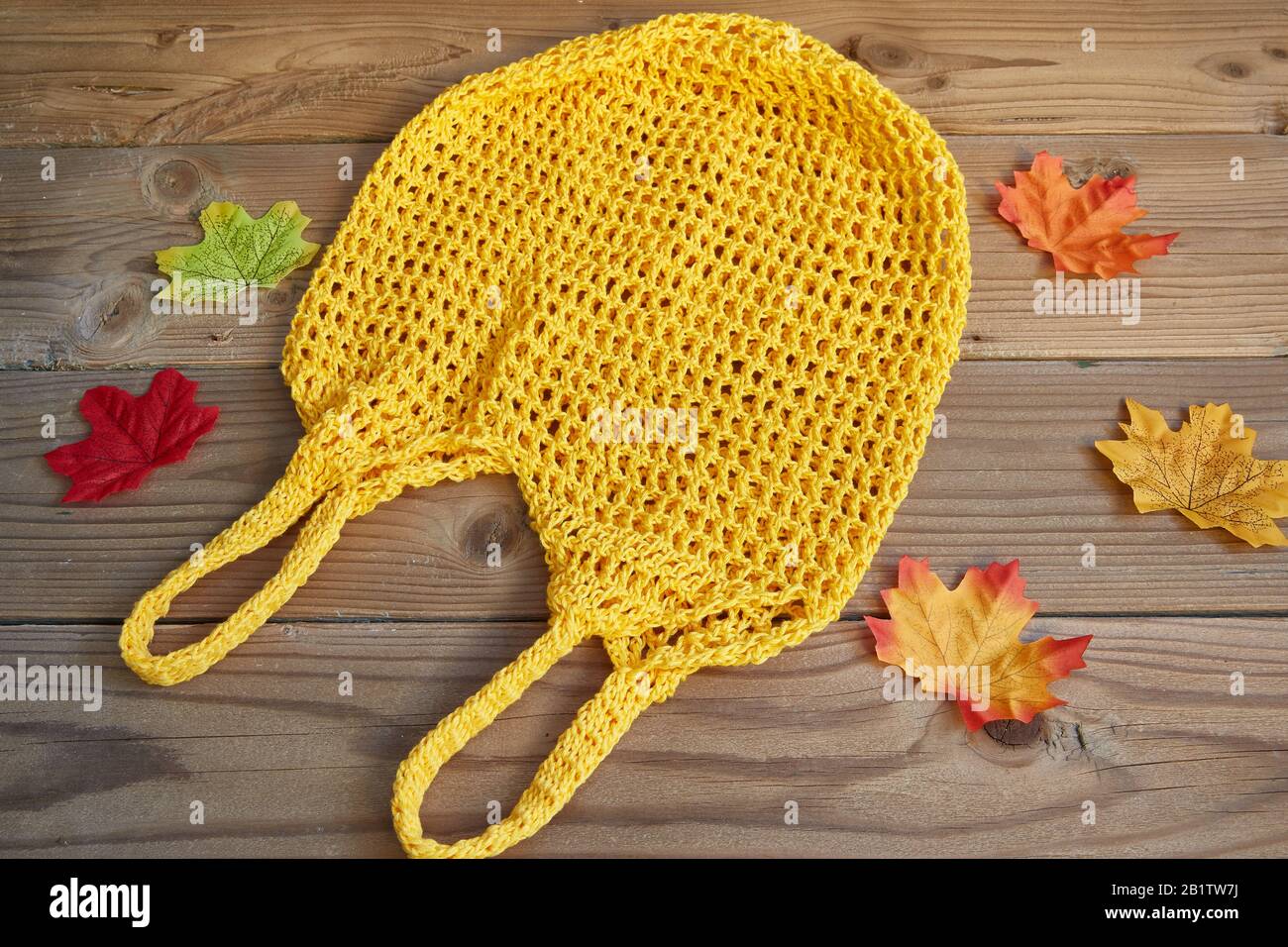 Gelbe Saite auf Holzhintergrund mit herbstlichen Blättern. Null-Abfall-Konzept. Stockfoto