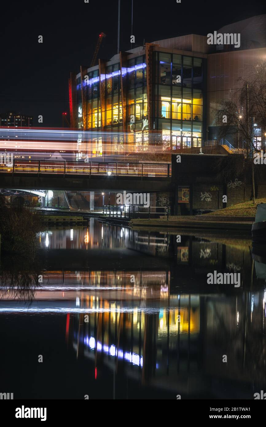 Lange Belichtung eines Busses, der nachts eine Kanalbrücke im Zentrum von Birmingham, Großbritannien überquert Stockfoto