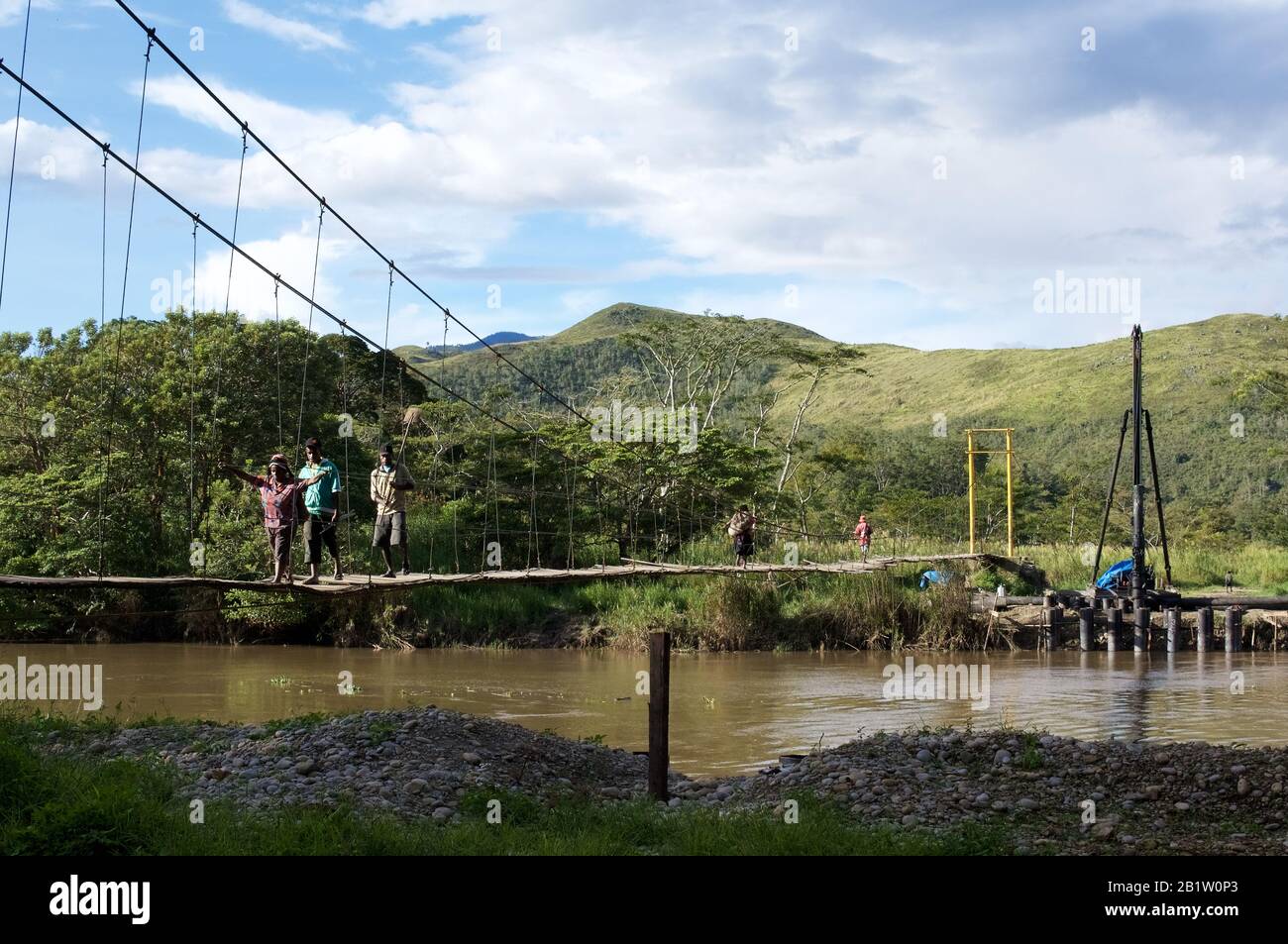 Papuaner, die auf einer Hängebrücke in Wesaput spazieren, kleines Dorf, das Wamena - Occidental Papua, Indonesien berührt Stockfoto