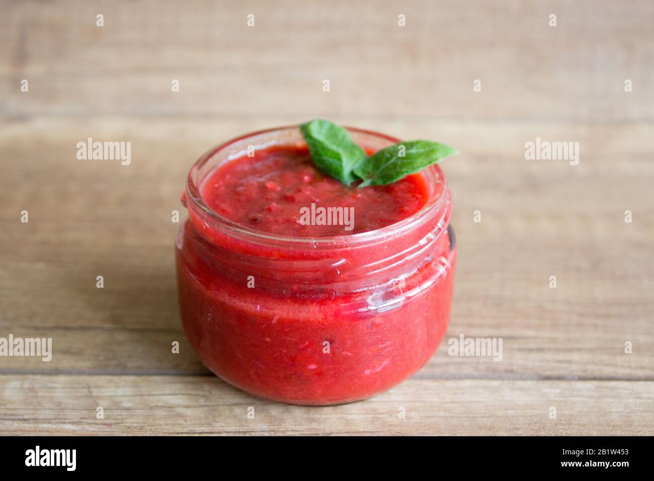 Hausgemachte, frische Tomatensauce in einem Glasbecher Stockfoto