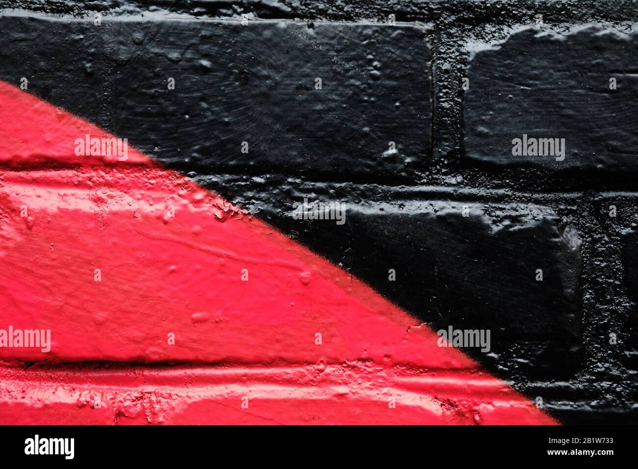 Ziegelwand als diagonale Textur in schwarz-roter Farbe. Nahaufnahme. Stockfoto