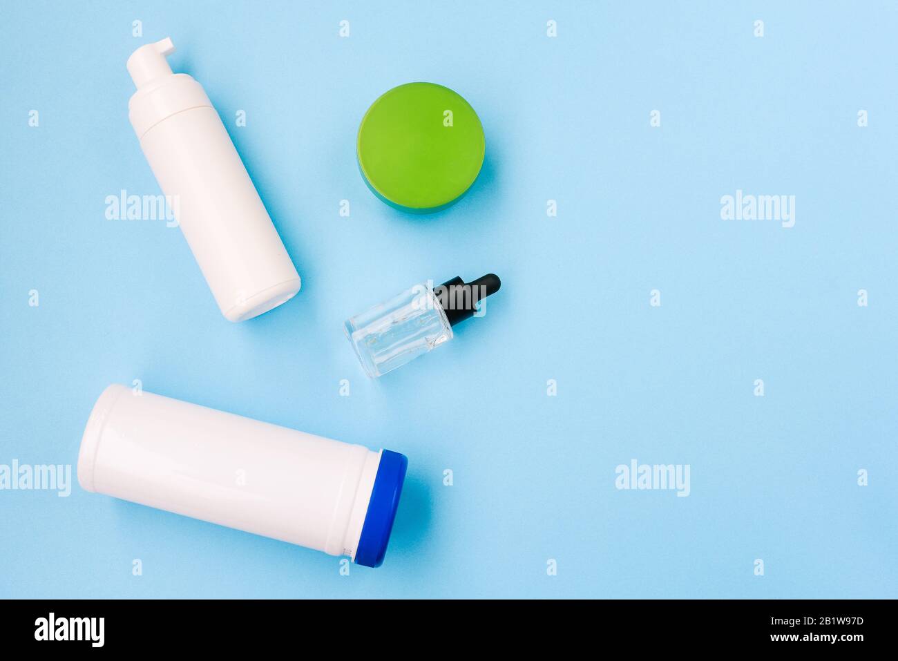 Kosmetische Produkte auf blauem Hintergrund mit Kopierbereich. Flasche für nasse Wischtücher, Gesichtscreme, Lotion und nagellackentferner Stockfoto