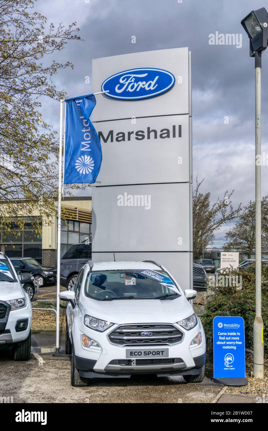Ford Eco Sport Auto zum Verkauf vor einem Ford-Händler, mit einem großen Ford-Zeichen und Logo. Stockfoto