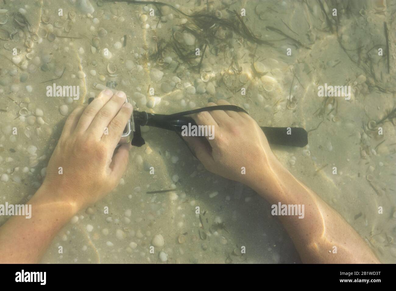 Männer halten Action-Kamera unter Wasser. Sommerurlaub am Meer. Stockfoto