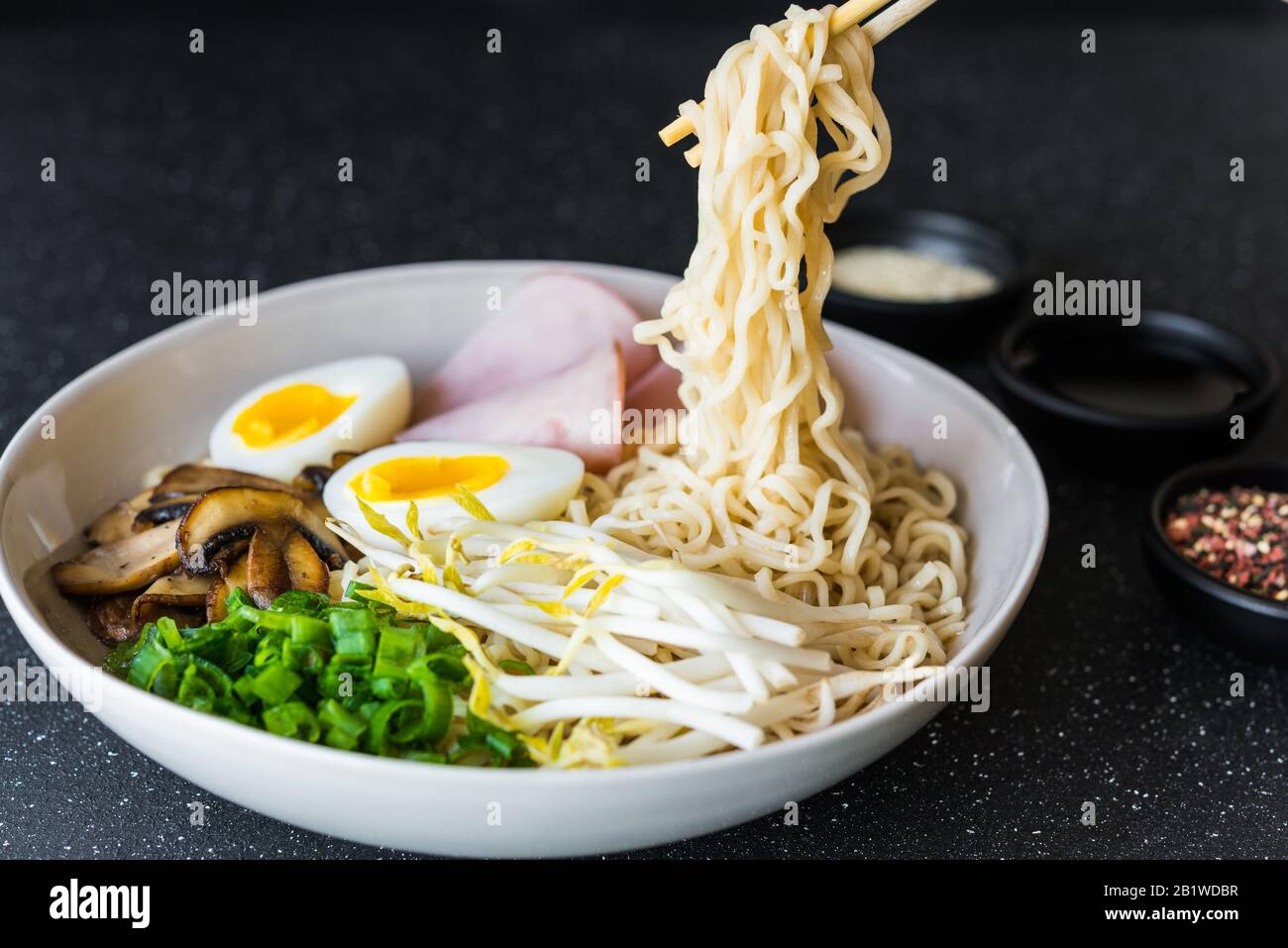 Eine Schüssel mit asiatischem Essen rammen Nudeln Suppe vor schwarzem  Steinhintergrund Stockfotografie - Alamy