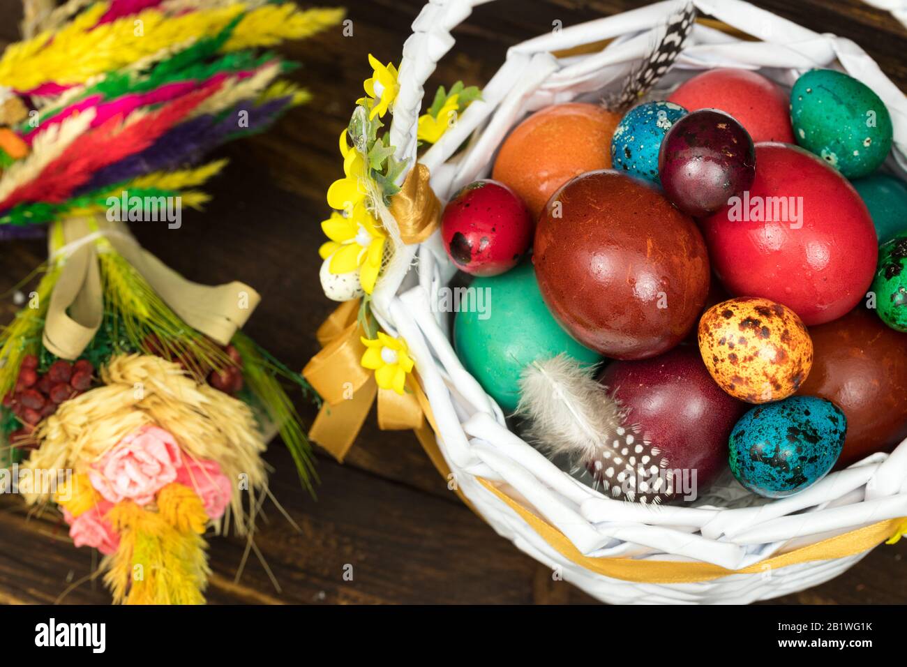 Frohe Ostern. Traditionell werden in einem Korb bunt bemalte Eier abgelegt. Hintergrund alter Bretter, festliches Dekor Stockfoto