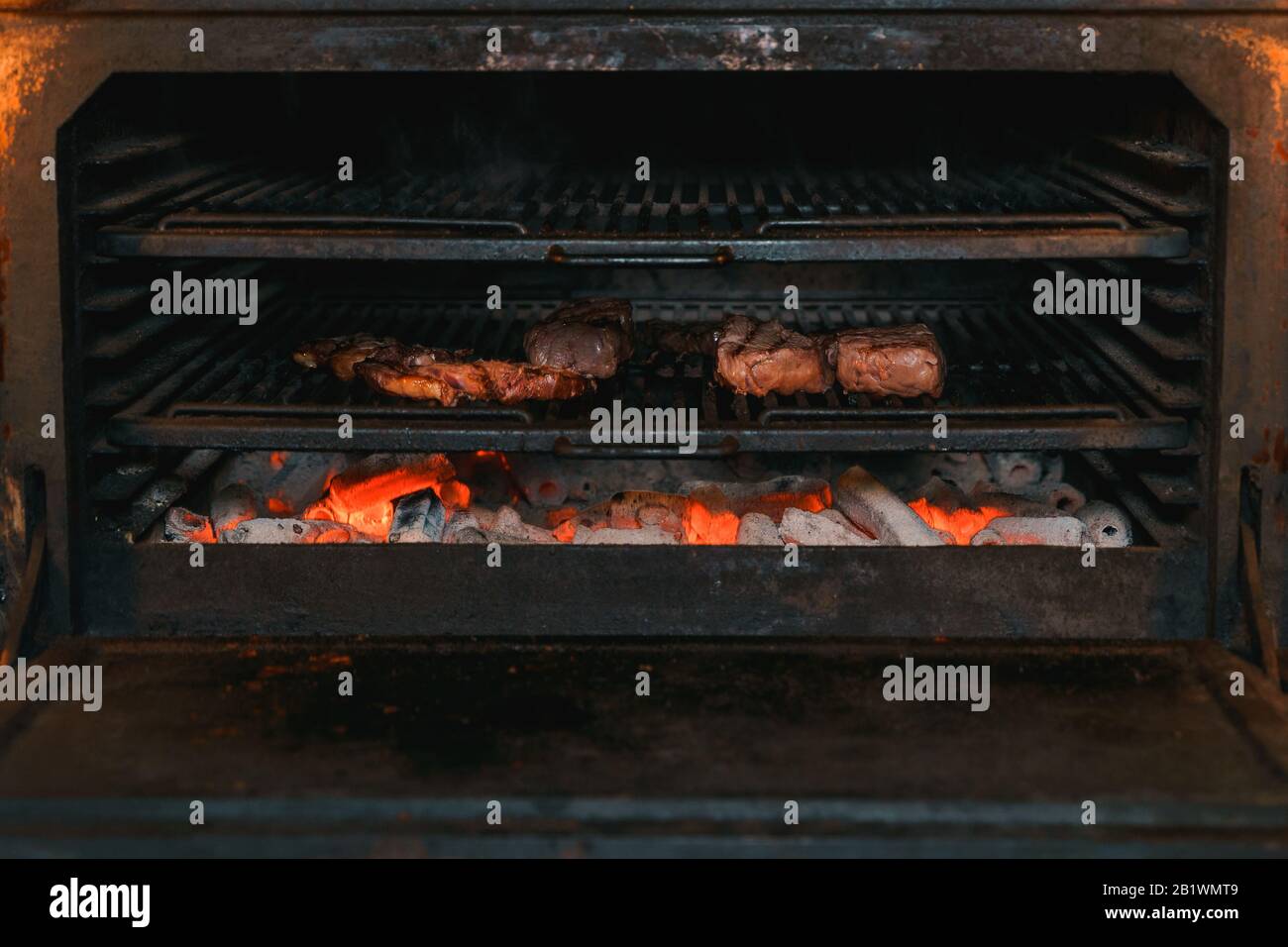 In einem Holzkohlegrill werden Rindersteaks gekocht Stockfoto