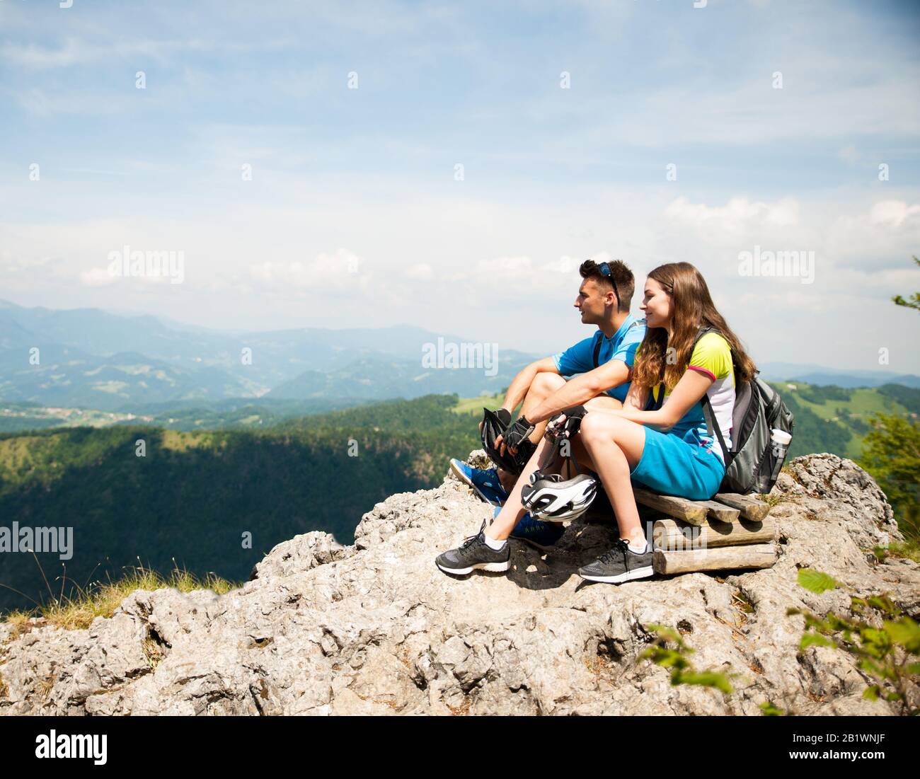 Aktives Paar ruht nach dem Fahrradfahren auf einer Bergkuppe Stockfoto