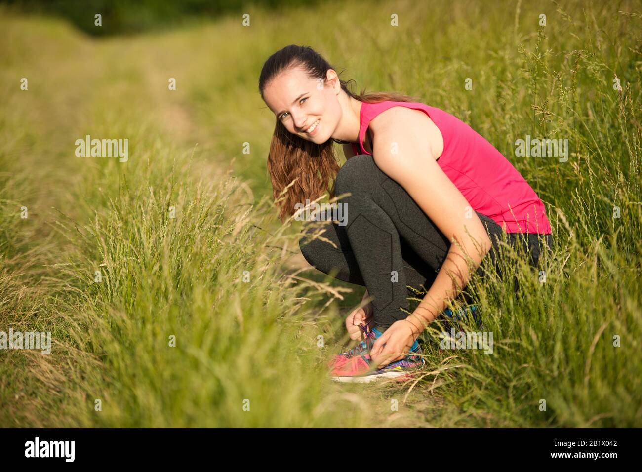 Schöne junge Frau Läufer Krawatte Schuhe Schnürsenkel vor dem Training laufen Stockfoto