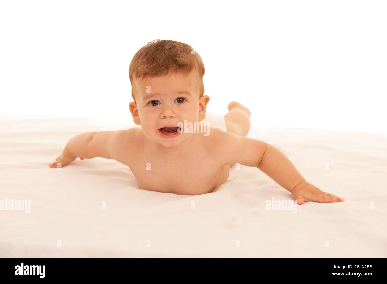 Hapy Baby Junge beim Spielen auf dem Bett isoliert über weiß Stockfoto