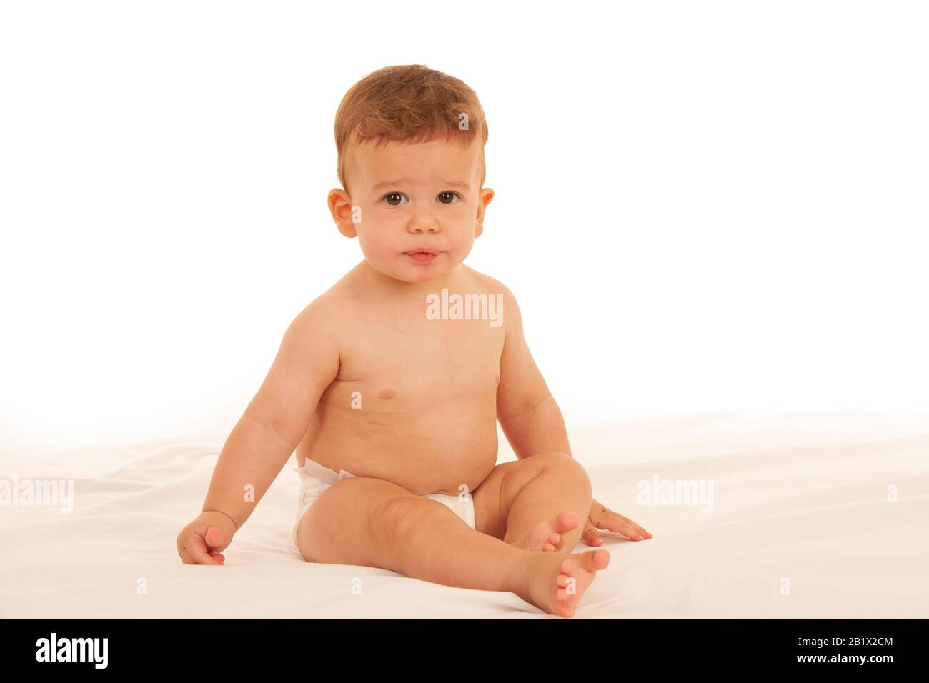 Hapy Baby Junge beim Spielen auf dem Bett isoliert über weiß Stockfoto