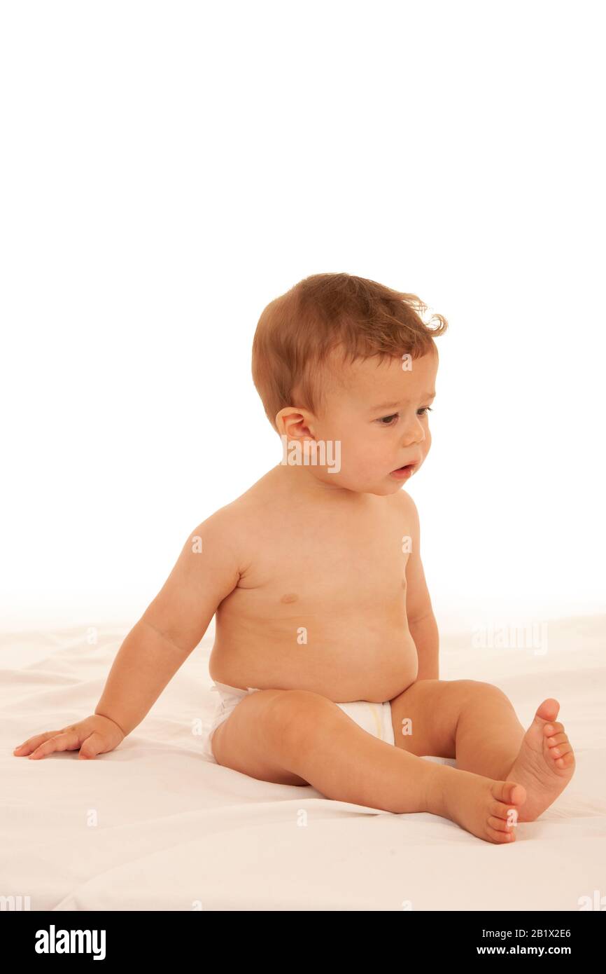 Hapy Baby Junge beim Spielen auf dem Bett isoliert über weiß Stockfoto