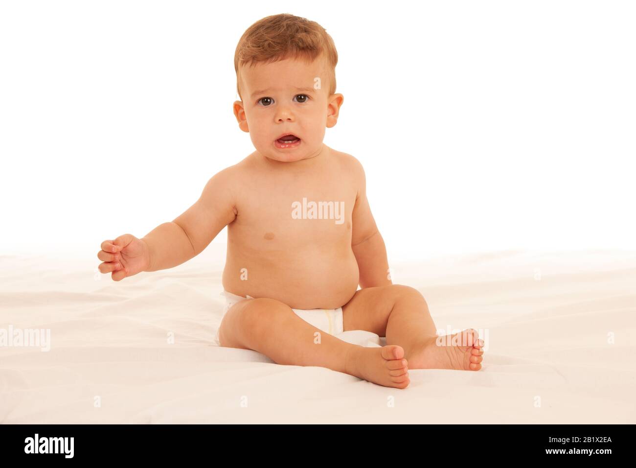 Hapy Baby Junge beim Spielen auf dem Bett isoliert über weiß Stockfoto