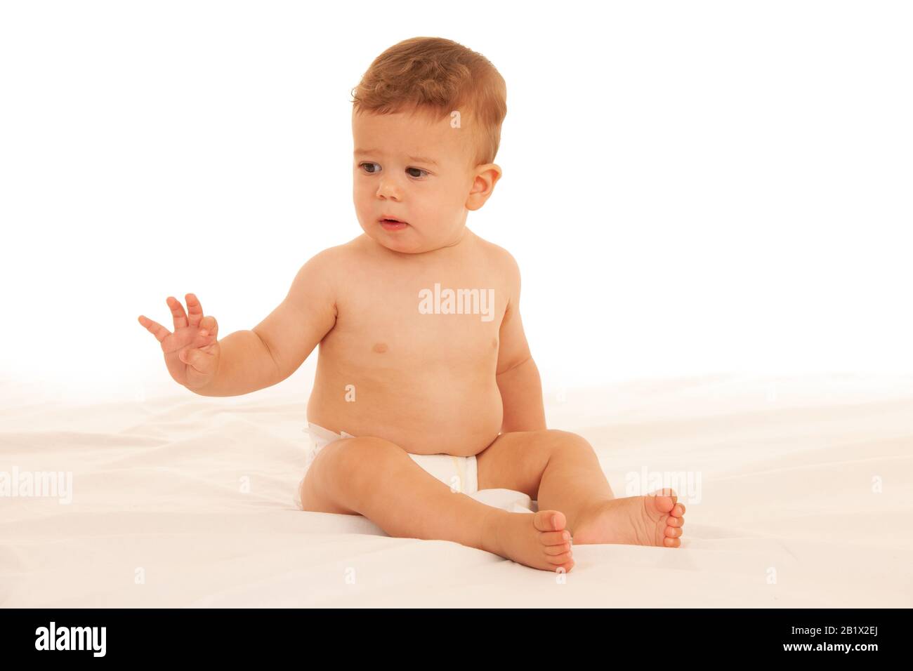 Hapy Baby Junge beim Spielen auf dem Bett isoliert über weiß Stockfoto