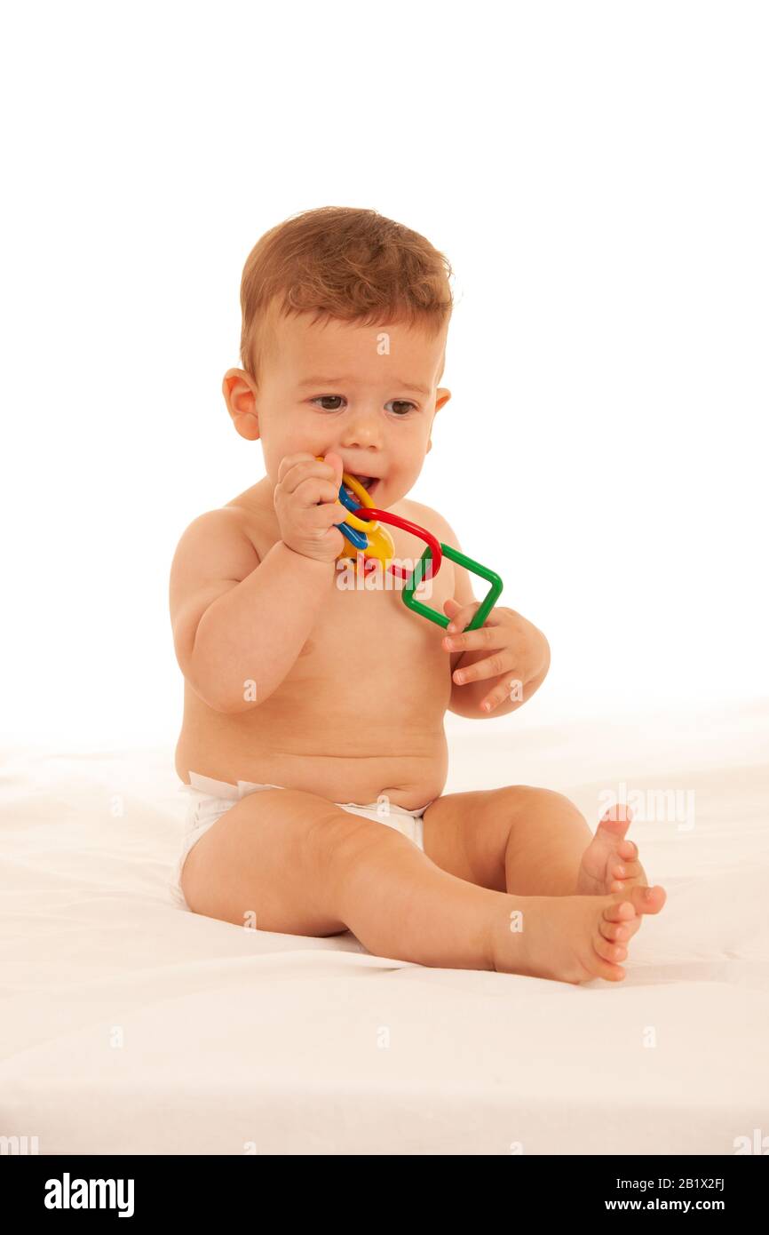 Hapy Baby Junge beim Spielen auf dem Bett isoliert über weiß Stockfoto