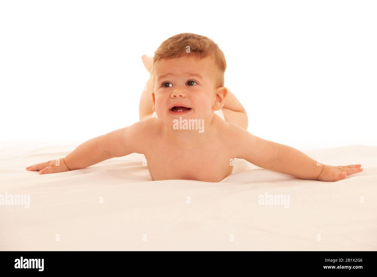 Hapy Baby Junge beim Spielen auf dem Bett isoliert über weiß Stockfoto