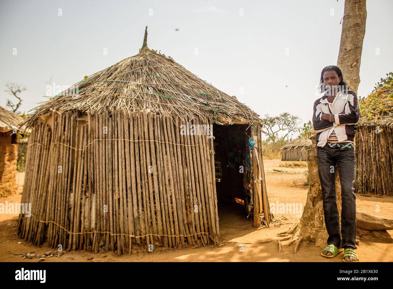 Ein Hausa/Fulani-Junge posieren zum Foto vor einem Strohhaus in einem Dorf in Abuja, Nigeria. Stockfoto