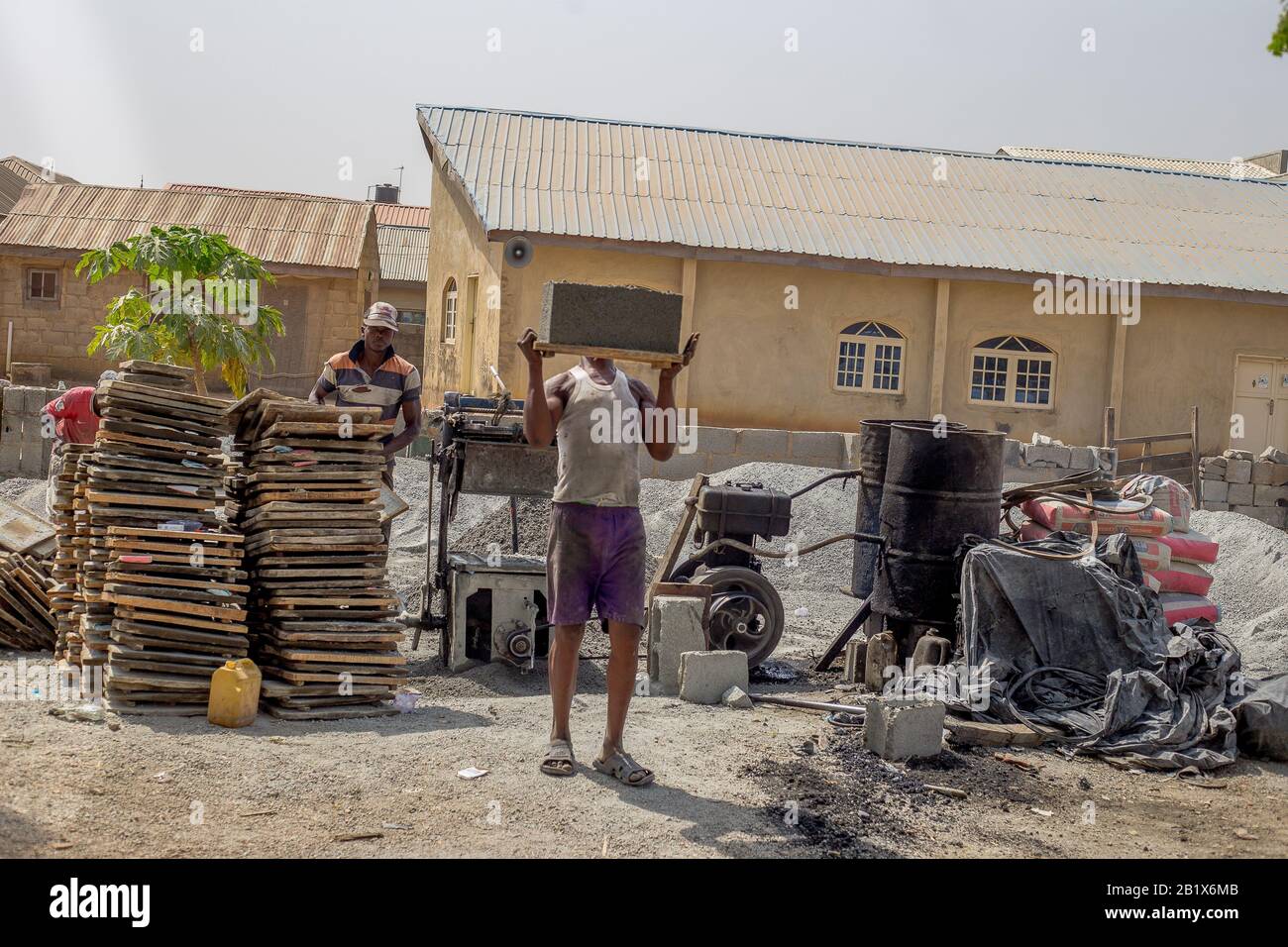 Ein Mann legte in einer Fabrik in Abuja, Nigeria, Ziegelsteine aus. Stockfoto