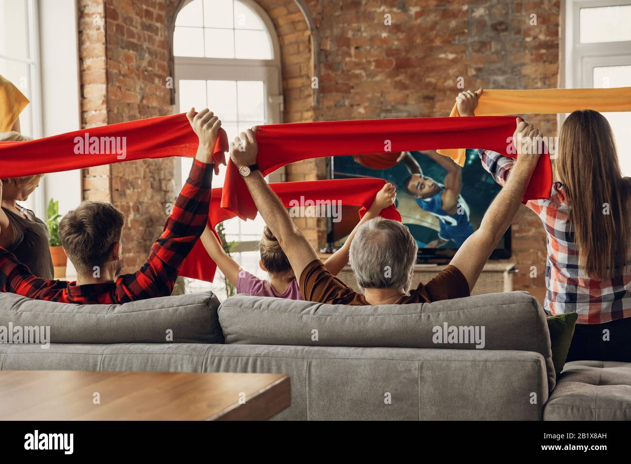 Sieg. Aufgeregt, glückliche Familie beim Basketballspiel, Meisterschaft auf der Couch zu Hause. Fans emotional jubeln für Lieblings-Nationalmannschaft. Tochter, Vater und Opa. Sport, Fernsehen, Spaß haben. Stockfoto