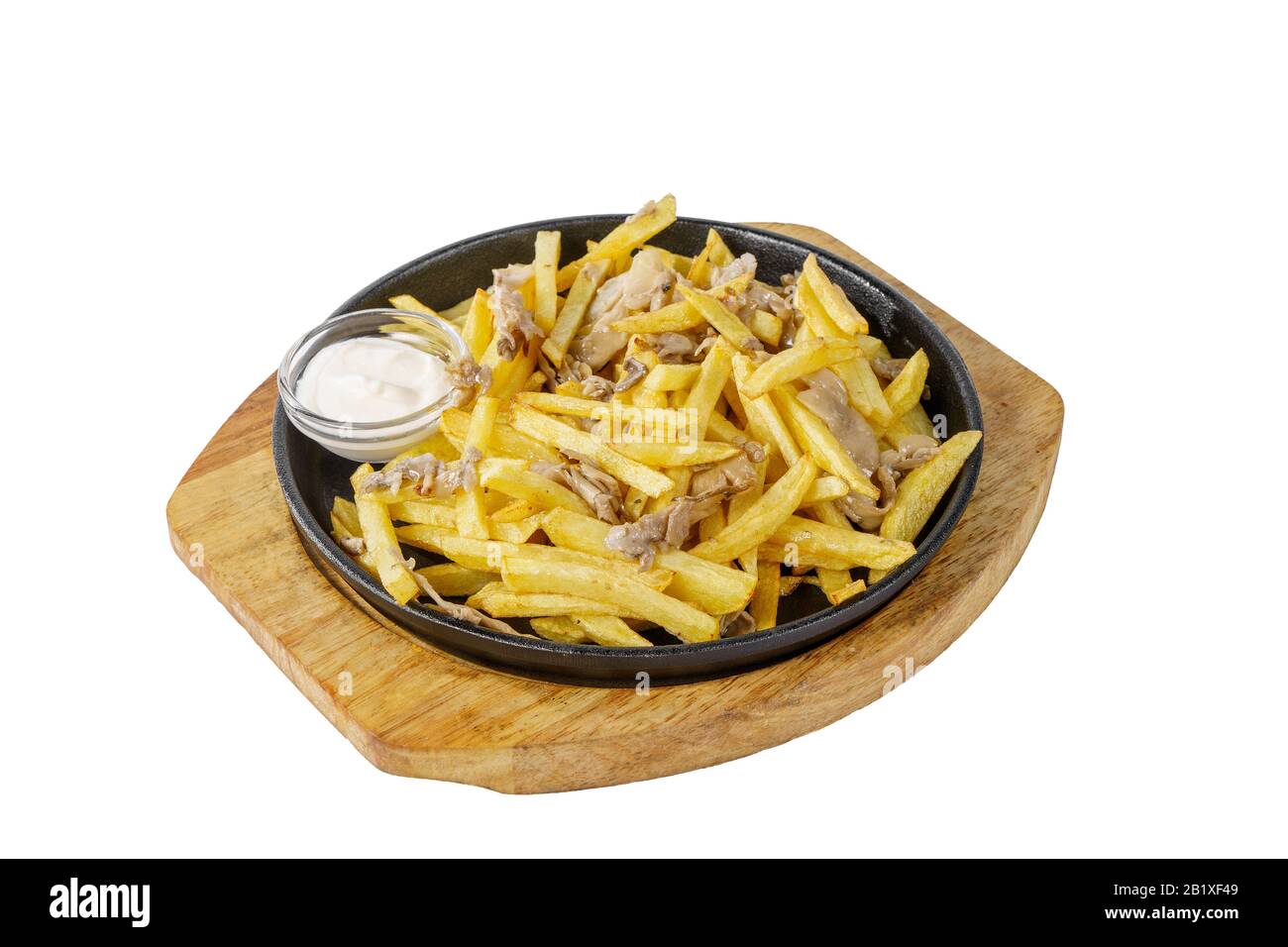 Kartoffeln, Pommes frites mit Fleisch, Huhn, Schweinefleisch, mit saurer Sahnesauce, gebratener, gebackener Portion auf einer heißen Bratpfanne, auf einem Holzbrett auf einem weißen Backgrot Stockfoto