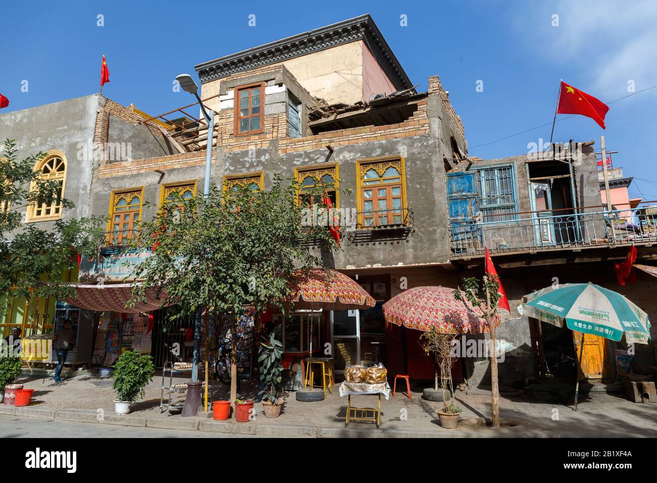Haus in der Kaschgar-Altstadt. An den Seitenwänden und auf dem Gebäude sind mehrere chinesische Flaggen angebracht. Während des chinesischen Nationalfeiertags gefangen genommen. Stockfoto