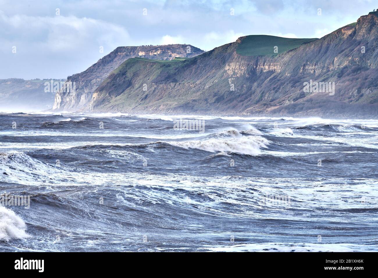 Stürmisches Winterwetter, Küste des Jura-Erbes, Ärmelkanal, West Bay, Dorset, England, mit Thornecombe Beacon und Golden Cap im Hintergrund. Stockfoto