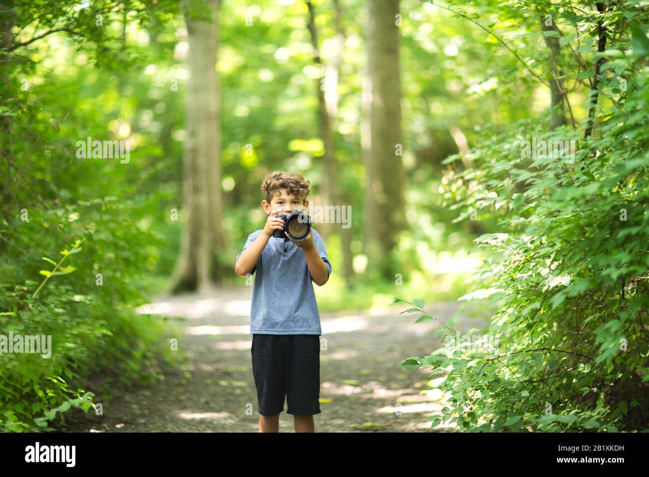 Kleiner Junge, der im Wald fotografieren kann. Stockfoto