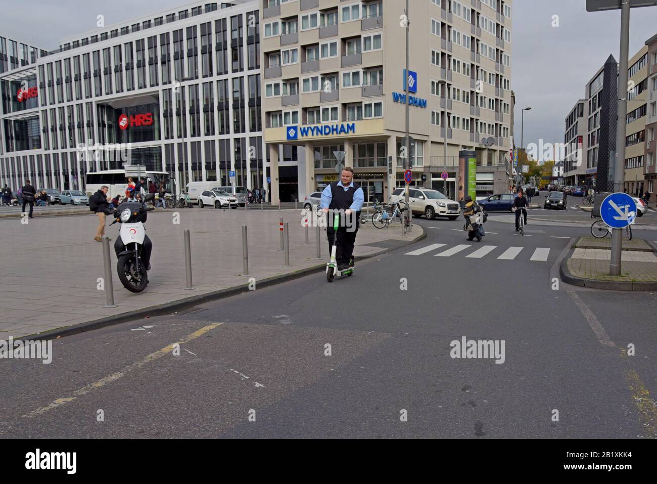 Ein Mann fährt mit einem fahrerlosen elektrischen Roller vom Typ Lime S auf der Straße nach Koln HBF, dem Hauptbahnhof in Köln Stockfoto