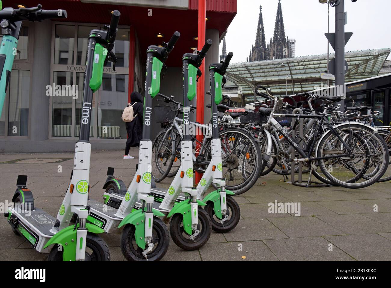 Eine Reihe von Lime S Dockless Elektro-Rollern, die neben einem Fahrradträger in der Kölner Innenstadt geparkt sind Stockfoto
