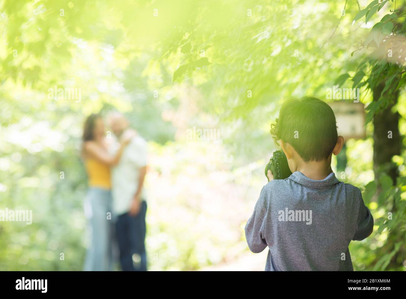 Kleiner Junge, der Fotos von seinen Eltern im Wald machte. Stockfoto
