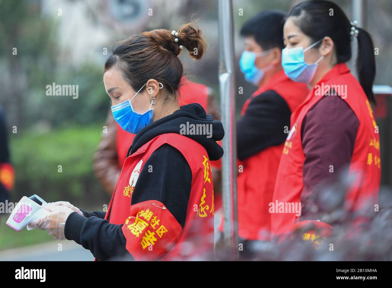 Changsha, China. Februar 2020. Li Wei (L) und andere Freiwillige stehen vor einer Gemeinde in Changsha, der zentralchinesischen Provinz Hunan, 27. Februar 2020. Li Wei, eine 39-jährige Lehrerin im Kindergarten, war im Kampf gegen den Ausbruch des Coronavirus beschäftigt. Wegen des Mangels an Mitarbeitern in ihrer Gemeinde meldete sich Li mit einigen Bewohnern zusammen, um Freiwillige zu werden, um die Prävention und die Kontrollarbeit während des Kampfes gegen die Epidemie zu fördern. Kredit: Xinhua/Alamy Live News Stockfoto