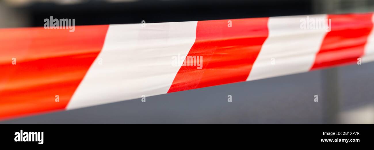 Isolierte Ansicht auf rot-weiß gestreiftem Kunststoffband. Begrenzung zum Abschließen von Bereichen. Z. B. bei Unfällen, Tatorten, Baustellen. Stockfoto